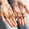 gold, silver, and rose gold Personalized Birthstone Initial Bracelets on model's palms
