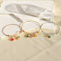 rose gold, gold, and silver Personalized Birthstone Initial Bracelets on white plain rocks
