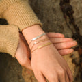 model wearing three colors of the Minimalist Chain Bracelets- silver, rose gold, and gold