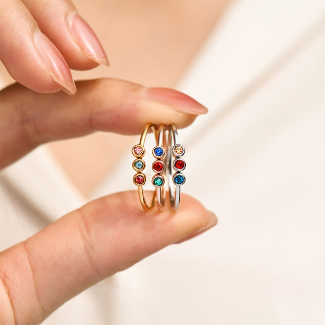 model holding 3 Minimalist Dainty Birthstone Ring with three birthstones per ring