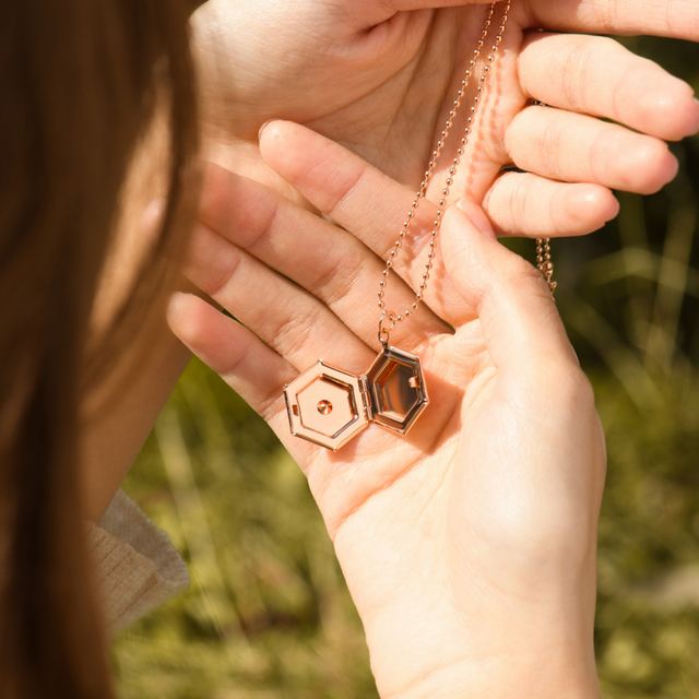 model holding an opened rose gold Pentagon Locket Necklace