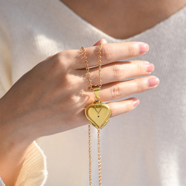model in white knitted long sleeve holding the Photo Locket Necklace