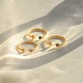 3 Initial Letter Birthstone Rings on clean canvas with light reflection
