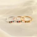 silver, gold, and rose gold Minimalist Dainty Birthstone Rings stack together on a plain canvas