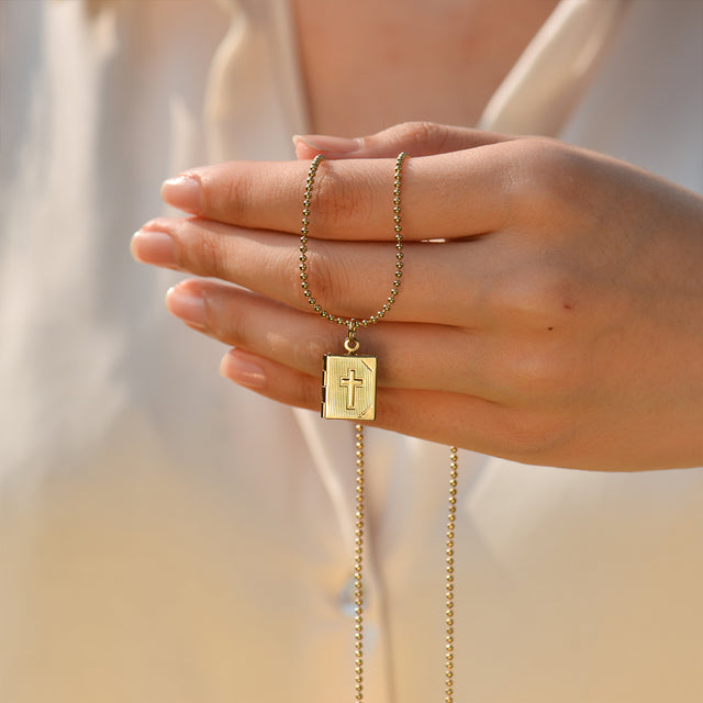 model holding the Cross Locket Necklace