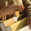 model holding the gold and silver Cross Photo Box Locket Necklace