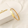 gold Custom Handwriting Bar Bracelet beside Carina white box packaging on a white canvas