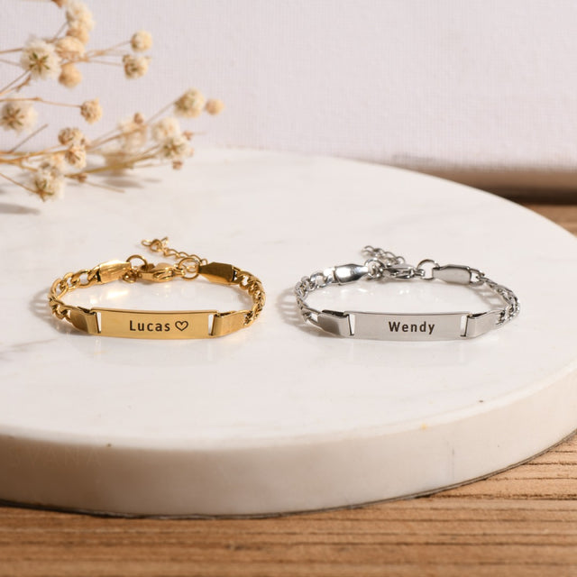 gold and silver Personalized Baby Name Bracelets on a white disc with flowers