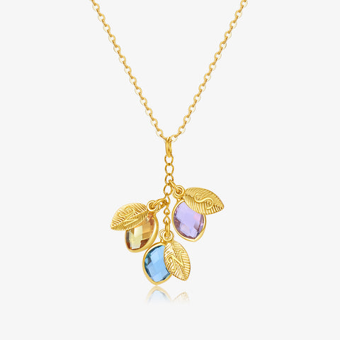 Dangling Birthstone Initial Necklace with three stones and leaves on a white background
