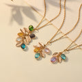 Dangling Birthstone Initial Necklaces on a plain canvas