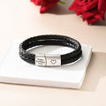 Personalized Braided Leather Bracelet on a white square disc with red roses behind it