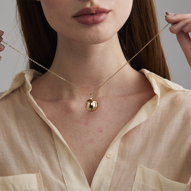model wearing the gold Round Ball Locket Necklace