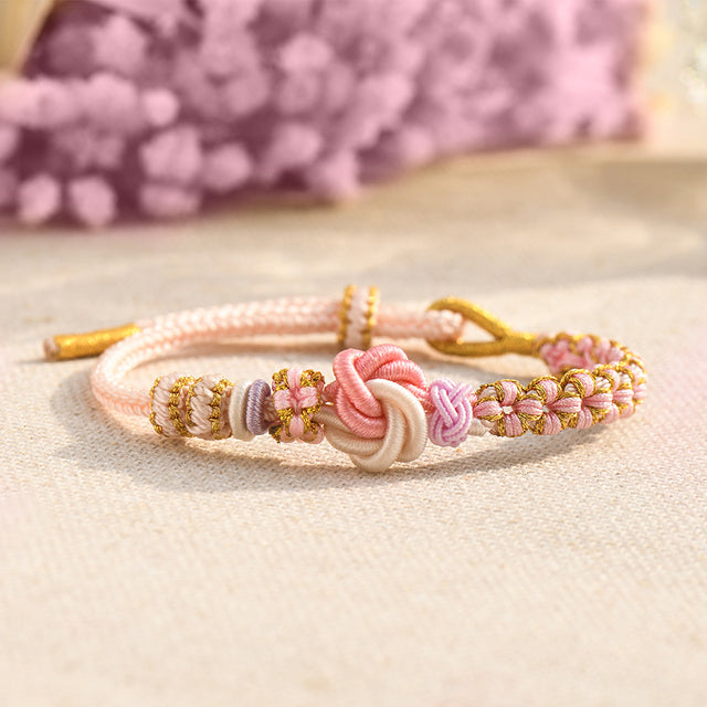 Peach Blossom Knot Bracelet on a beige canvass