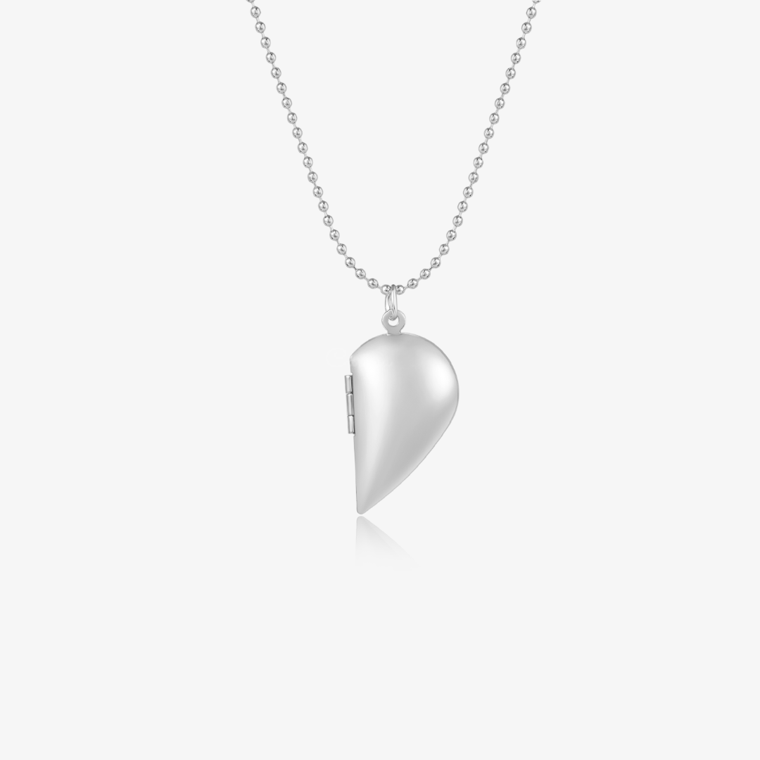 silver colored Couple's Heart Locket Necklace on a white background