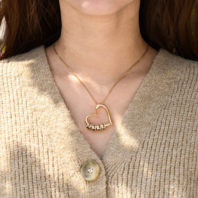 model wearing the gold colored personalized charming heart necklace with engraved beads