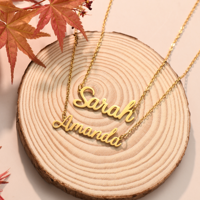 Gold Personalized Fairy Name Necklaces on a wooden flat lay.