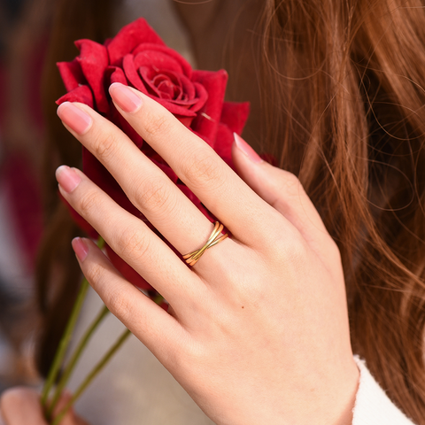 model, holding a red rose, wearing gold Dainty Interlocking Fidget Ring