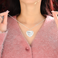 female model holding the silver engraved heart necklace