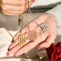 gold, rose gold, and silver Mom Birthstone Necklaces on model's palm