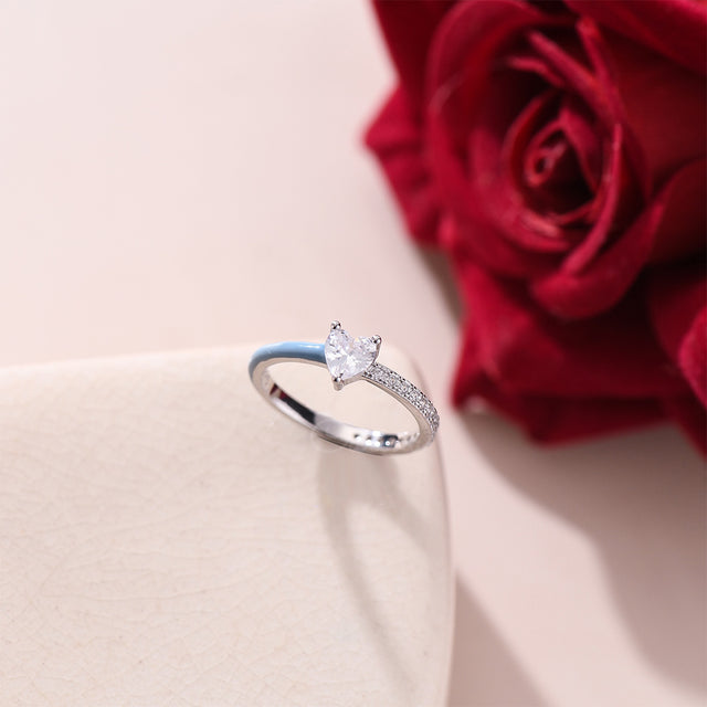 Half Enamel Ring on top of a white canvas and a red rose with it