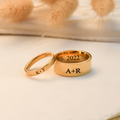 gold set of couple wearing the gold set of Personalized Initials Couple Ring on white canvas with leaves behind it