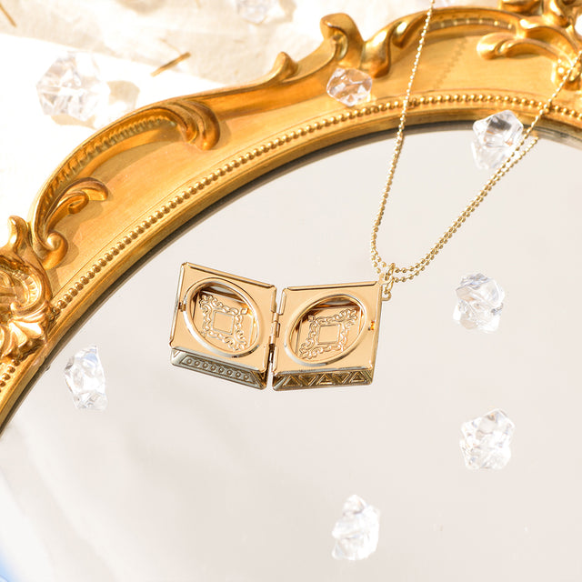 an opened Diamond Pattern Locket Necklace on a mirror with jewel stones