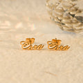 gold-colored Personalized Name Stud Earrings on a creative shot