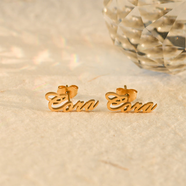 gold-colored Personalized Name Stud Earrings on a creative shot