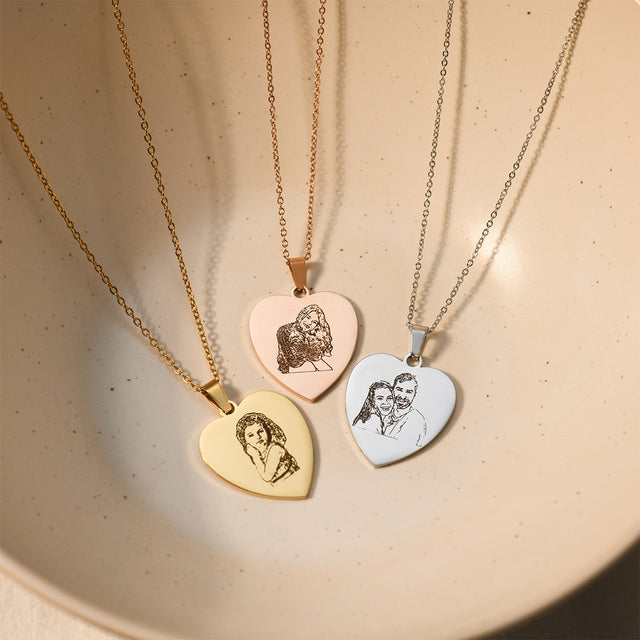 gold, rose gold and silver Photo Engraved Heart Necklaces on plain beige-colored background