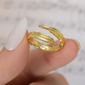 Model holding gold variant of Personalized Adjustable Plume Ring with engraving