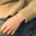 model wearing a gold-colored Custom Engraved Bangle