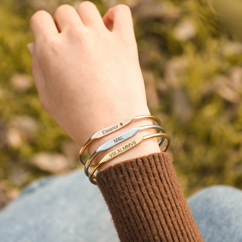 model wearing three Custom Engraved Bangles - rose gold, silver, and gold variants