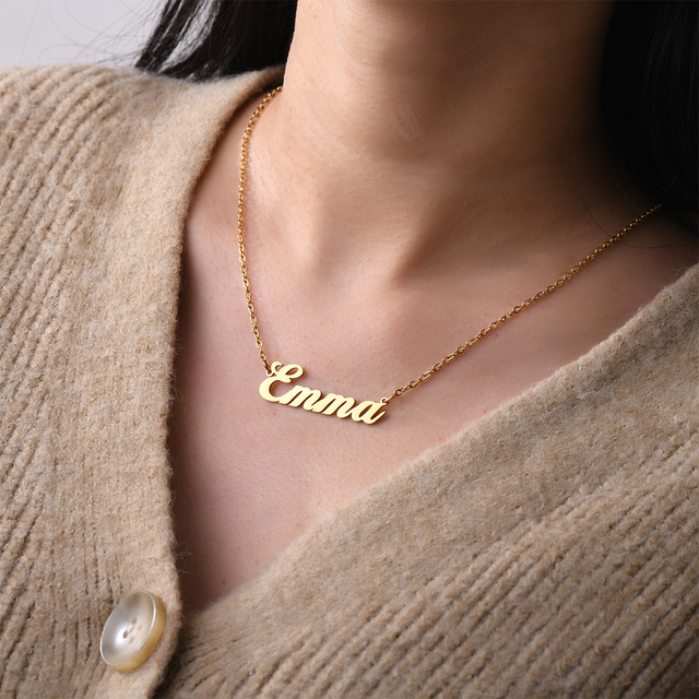 Personalized Emma Quill Name Gold Necklace worn by a woman.