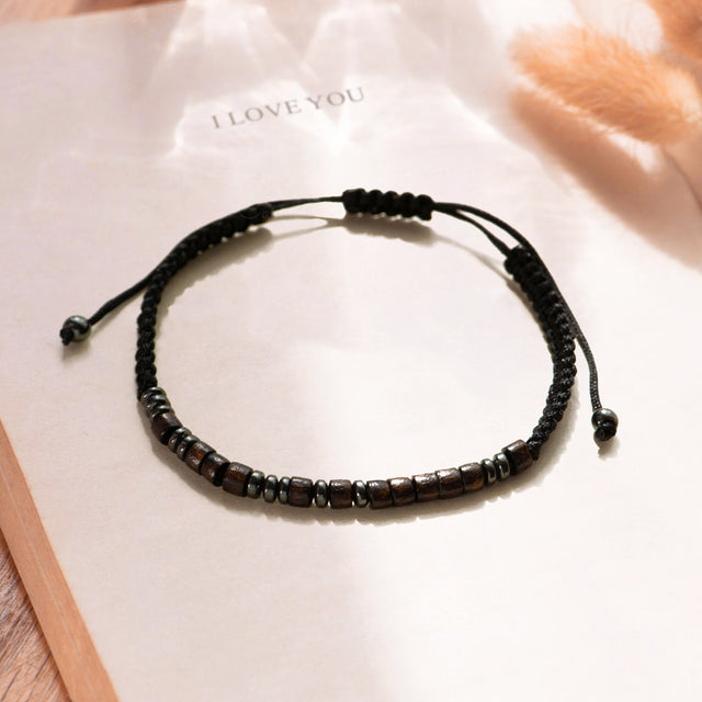 Lifestyle image of the "I Love You" morse code bracelet a book page.