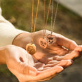 the three color variants of Custom Pet Portrait Necklace hanging above the model's hands