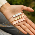 silver, gold, and rose gold Custom Birthstone Name Bar Necklace on model's palm